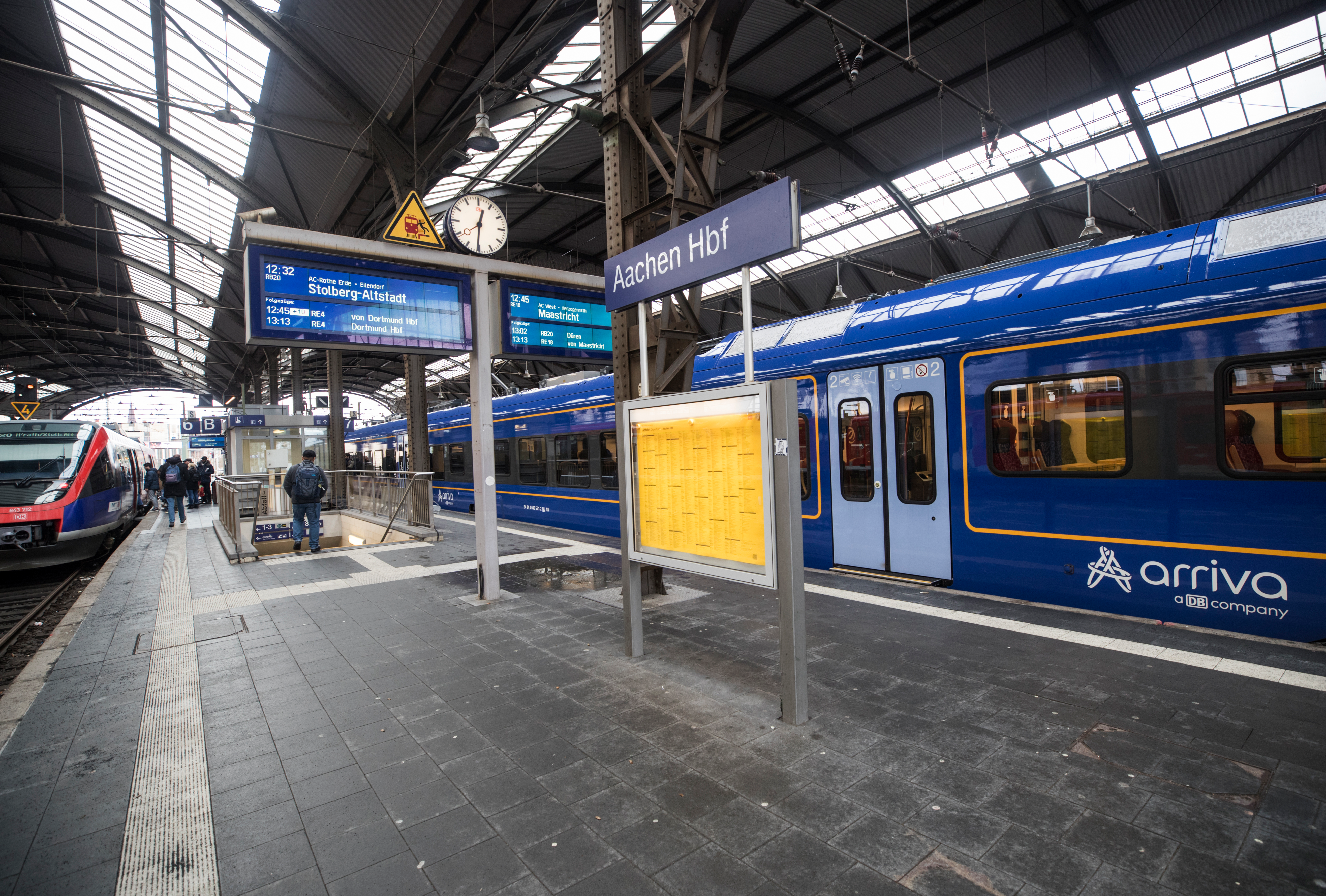 Blauwe trein van Arriva staat bij een perron op het station van Aken (Aachen) in Duitsland met bestemming Maastricht op het vertrekbord.