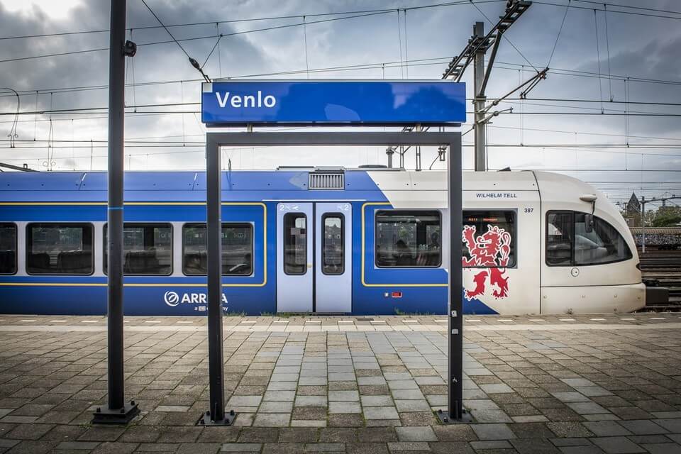 Een blauw-witte Arriva-trein staat aan het perron van station Venlo.