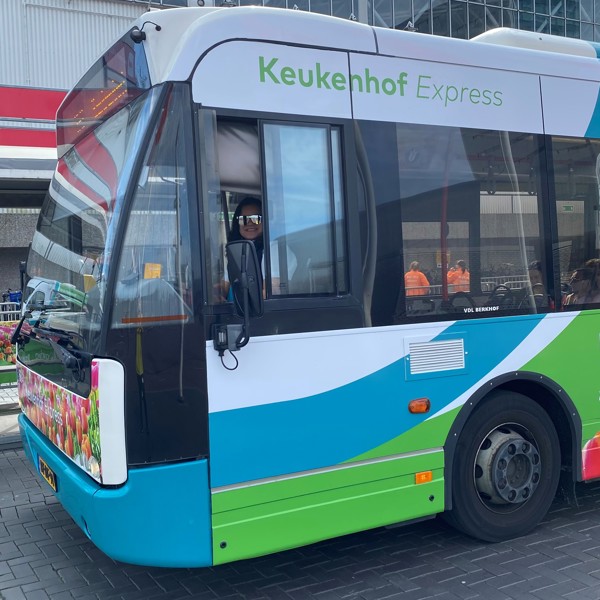 Arriva-bus 'de Keukenhof Express' met bloemendecoratie. Vrouwelijke buschauffeur achter het stuur.