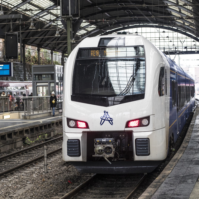 Blauw witte Arriva Drielandentrein staat met gesloten deuren klaar aan het perron van station Aken om in de richting van Maastricht-Luik te vertrekken.