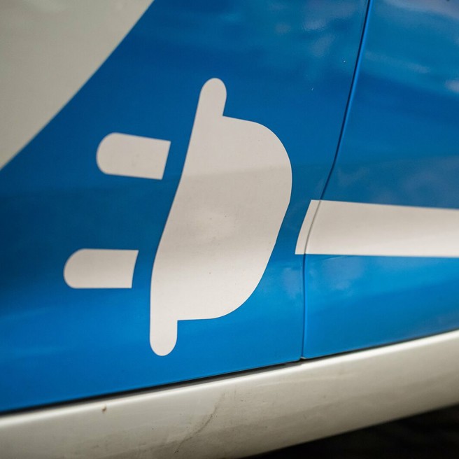 elektrische aangedreven Personeel Ophaal Dienst-auto wit stekkerlogo (elektrisch aangedreven) op de zij-onderkant van een blauw-witte Arriva Personeel Ophaal Dienst-auto