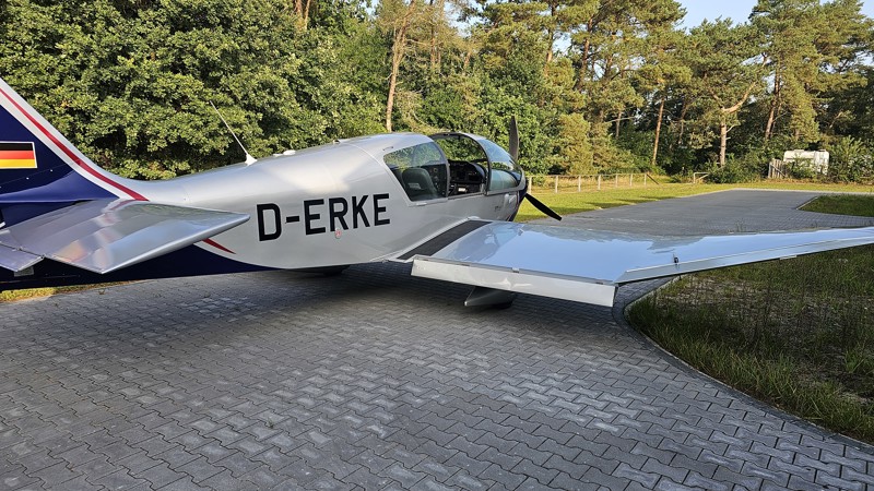 Klein grijs vliegtuigje met 'D-ERKE' erop staat op de grond. Klein grijs vliegtuigje met 'D-ERKE' erop staat op de grond.