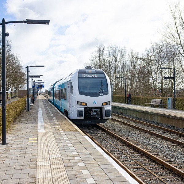 Blauwe trein van Arriva richting Leeuwarden staat stil op een klein station bij een leeg perron op een winterse dag. Blauwe trein van Arriva richting Leeuwarden staat stil op een klein station bij een leeg perron op een winterse dag.