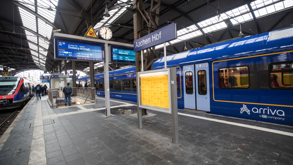 Blauwe trein van Arriva staat bij een perron op het station van Aken (Aachen) in Duitsland met bestemming Maastricht op het vertrekbord. Blauwe trein van Arriva staat bij een perron op het station van Aken (Aachen) in Duitsland met bestemming Maastricht op het vertrekbord.