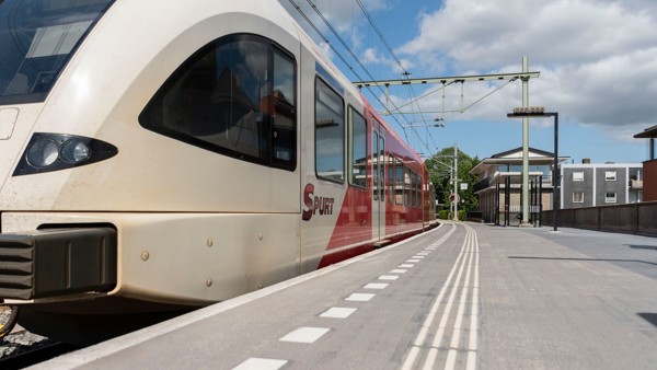 Roodwitte Arriva-trein staat stil met dichte deuren aan het perron van station Zutphen.
