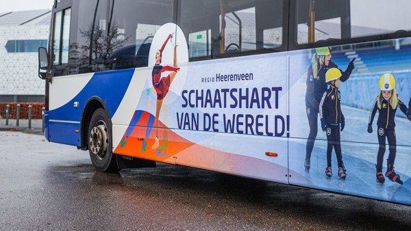 Bus van Arriva die speciaal naar Thialf rijdt met daarop stickers van sportende mensen en de tekst 'regio Heerenveen Schaatshart van de wereld!'