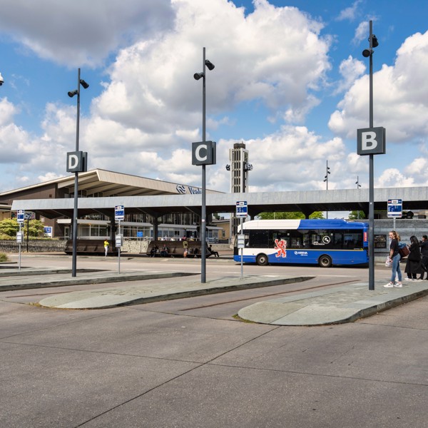 Een blauwwitte bus van Arriva staat aan de bushalte bij station Venlo.