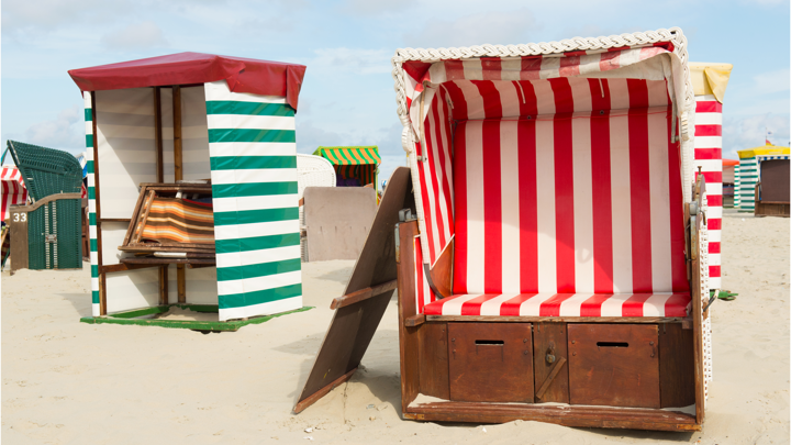 Ouderwetse strandhuisjes met blauwwitte en groenwitte doeken staan op het strand van Borkum. Ouderwetse strandhuisjes met blauwwitte en groenwitte doeken staan op het strand van Borkum.