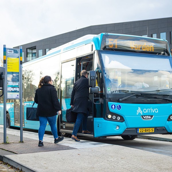 Blauwe bussen van Arriva, eentje met daarop '51 Vorden' staan bij de bushalte