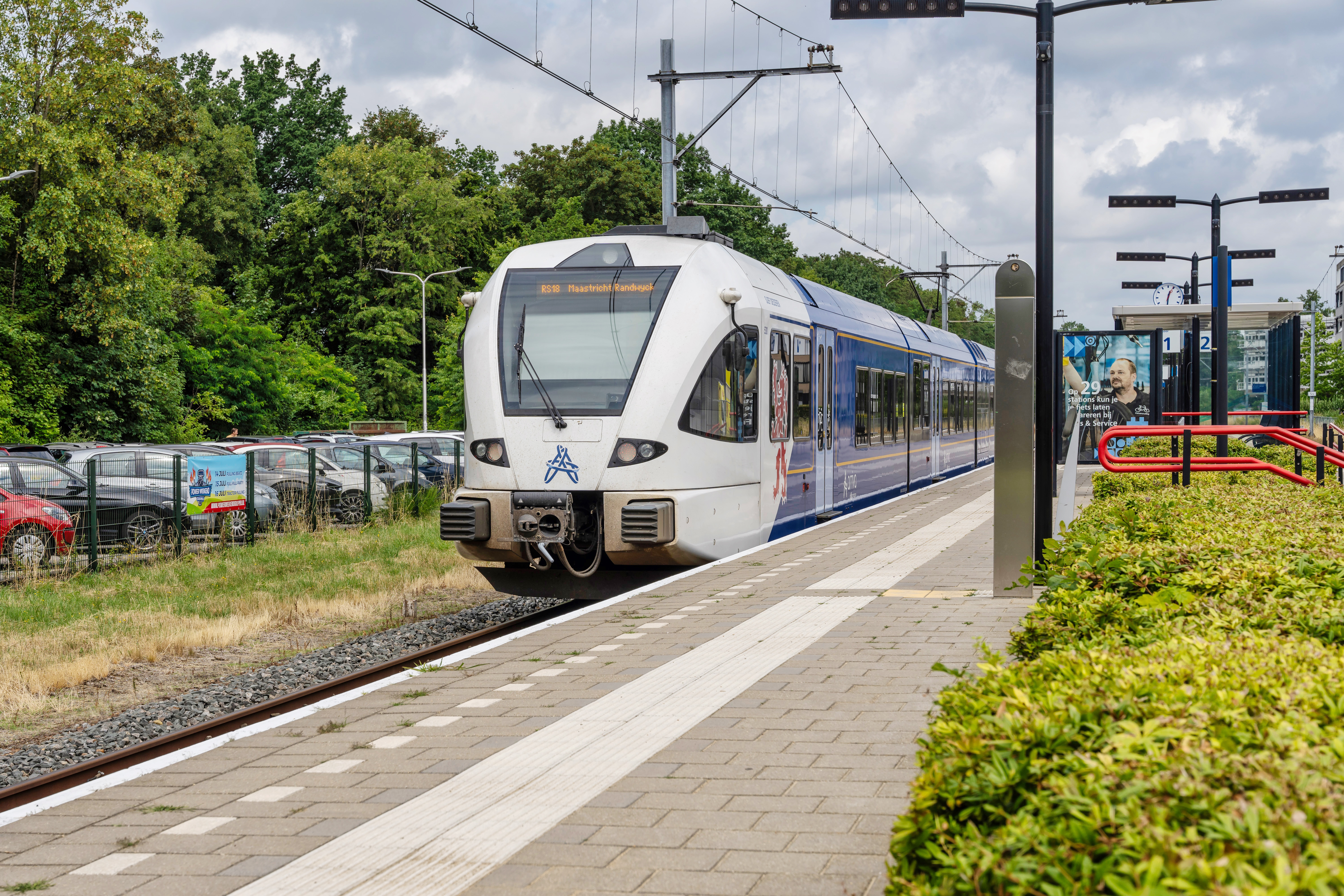 Blauwwitte trein van Arriva staat stil bij perron station Kerkrade Centrum.