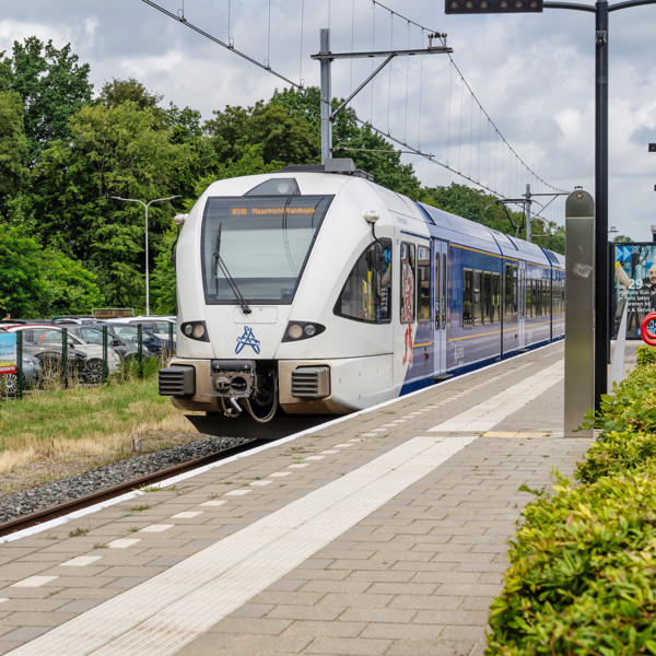 Blauwwitte trein van Arriva staat stil bij perron station Kerkrade Centrum.